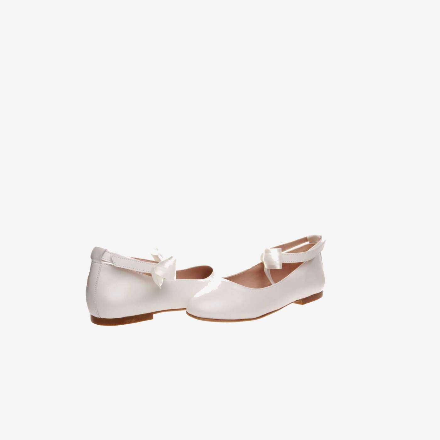 Mercedes de niña en piel beige con lazo.
