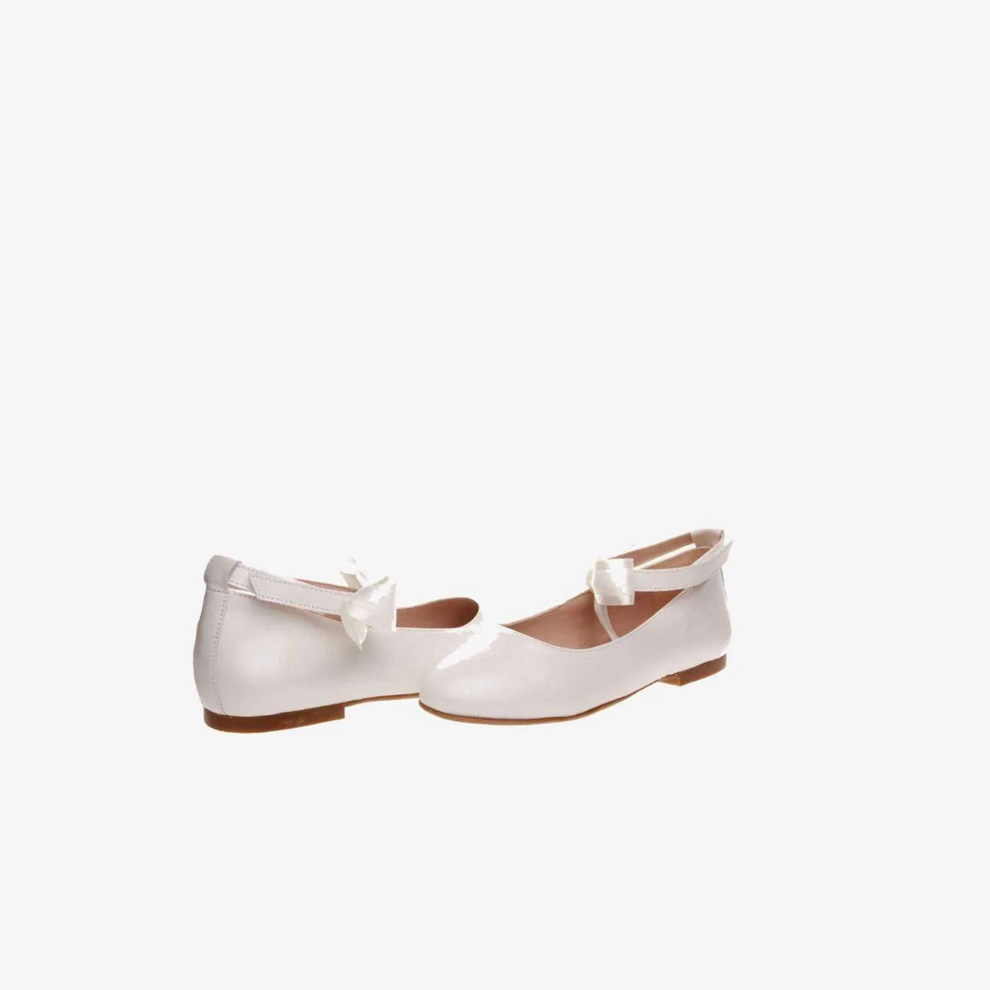 Mercedes de niña en piel beige con lazo.