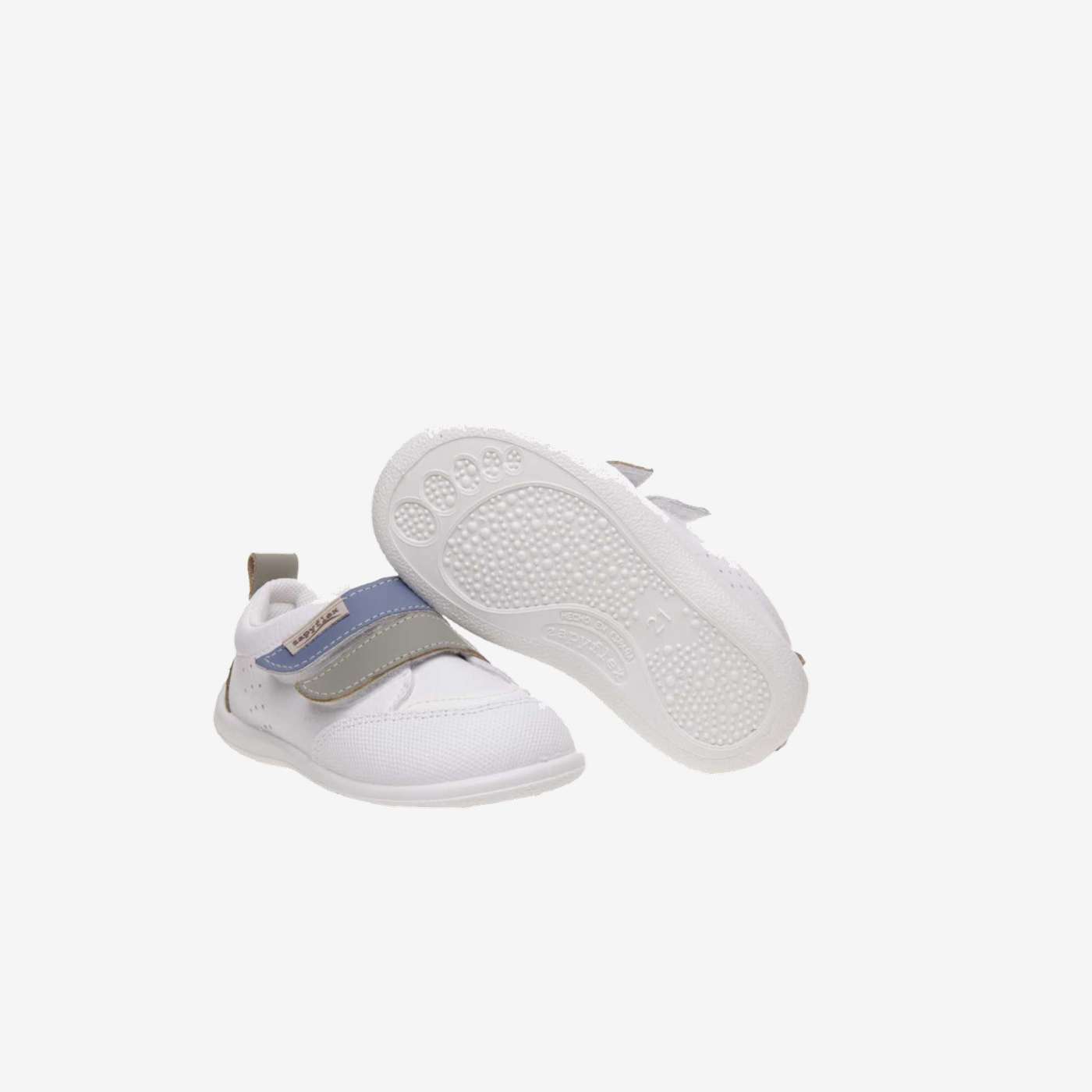 Deportivos respetusos primeros pasos con velcro y puntera reforzada en blanco con tiras en azul y verde.