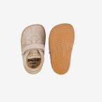 Deportiva niña respetuosa beige con toques dorados.