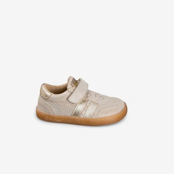 Deportiva niña respetuosa beige con toques dorados.