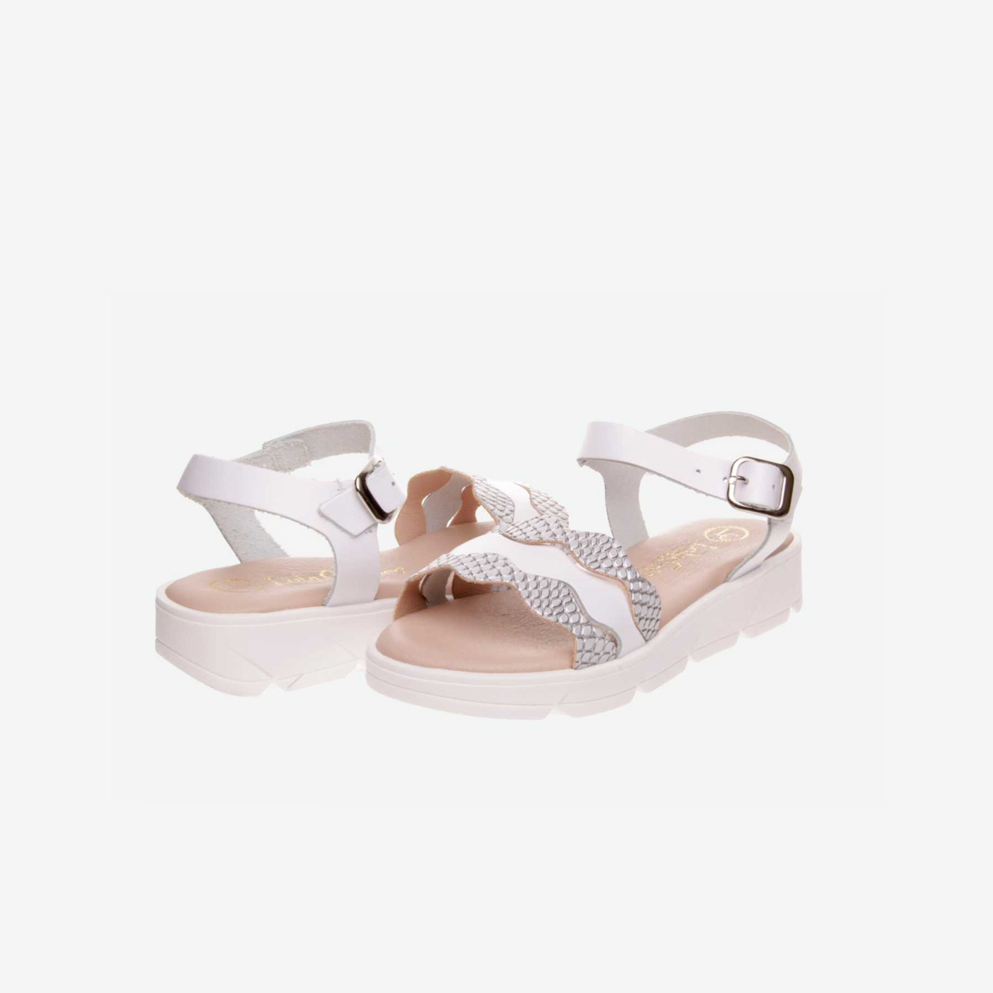 Sandalia de niña en blanco y plata con hebilla.